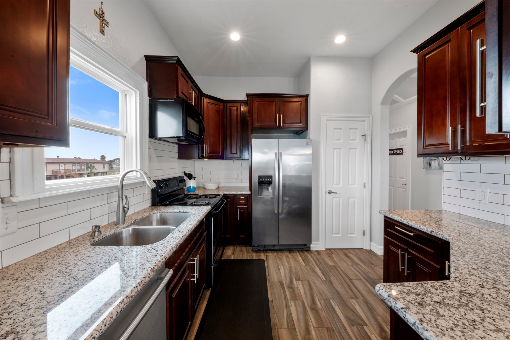 1026 20th Street Dickinson, TX 77539 - Photo 7 of 25 a kitchen with granite countertop a sink stove and refrigerator