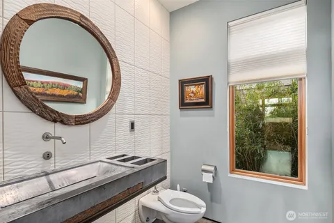 a bathroom with a toilet a sink and mirror