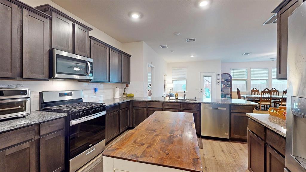 4005 Glastonbury Road McKinney, TX 75071 - Photo 11 of 39 a kitchen with stainless steel appliances granite countertop wooden cabinets stove top oven and granite counter top