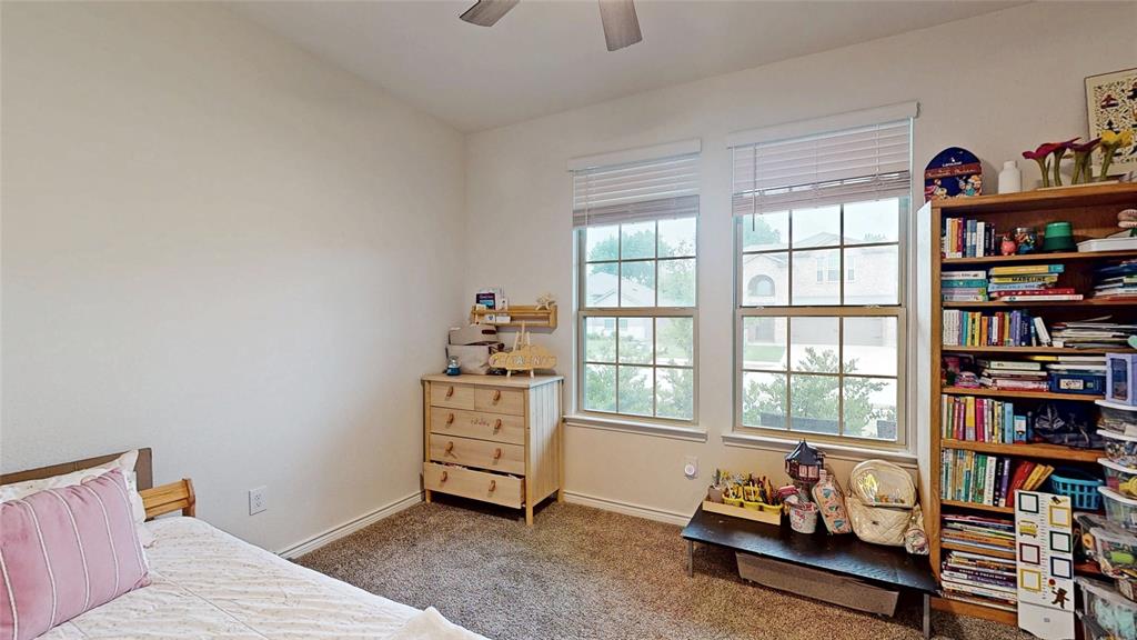 4005 Glastonbury Road McKinney, TX 75071 - Photo 30 of 39 a bedroom with furniture and a book shelf