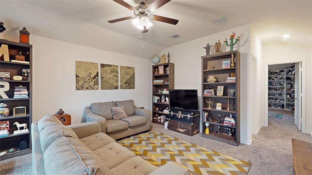 4005 Glastonbury Road McKinney, TX 75071 - Photo 32 of 39 a living room with furniture a book shelf and a bookshelf