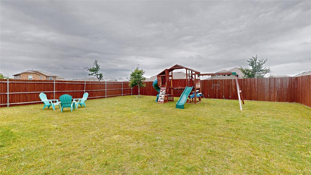 4005 Glastonbury Road McKinney, TX 75071 - Photo 39 of 39 a view of a garden with a slide and a wooden fence