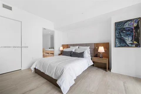 a bedroom with bed and wall painting