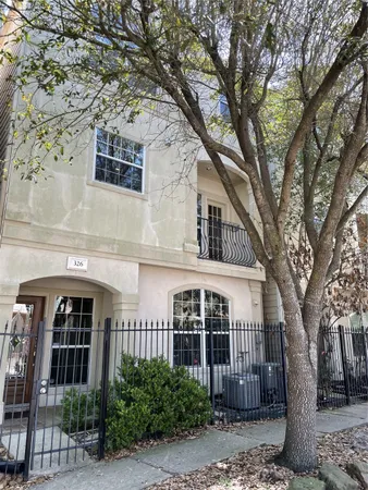a front view of a house with a tree