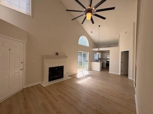 an empty room with wooden floor a fireplace and a window