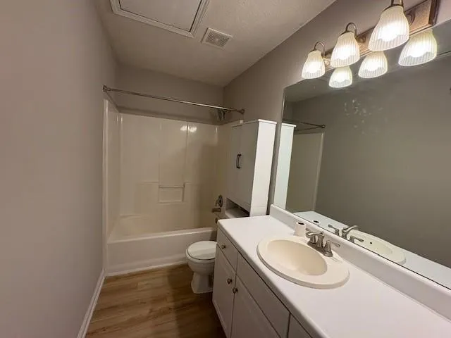 a bathroom with a sink a toilet a mirror and shower