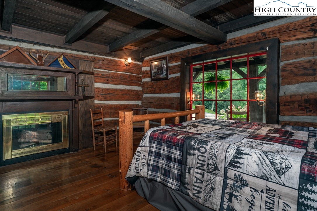 164 Avery Co High School Road Newland, NC 28657 - Photo 16 of 50 a bed sitting in a bedroom next to a fireplace