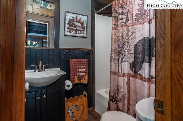 a bathroom with a sink and mirror with toilet