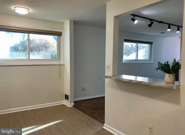 an empty room with wooden floor and windows