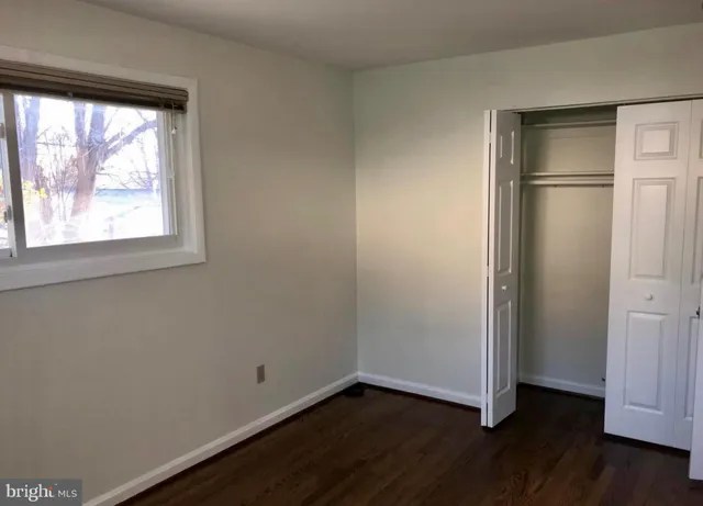 an empty room with wooden floor and a window