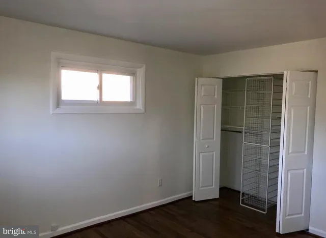 an empty room with wooden floor and entrance