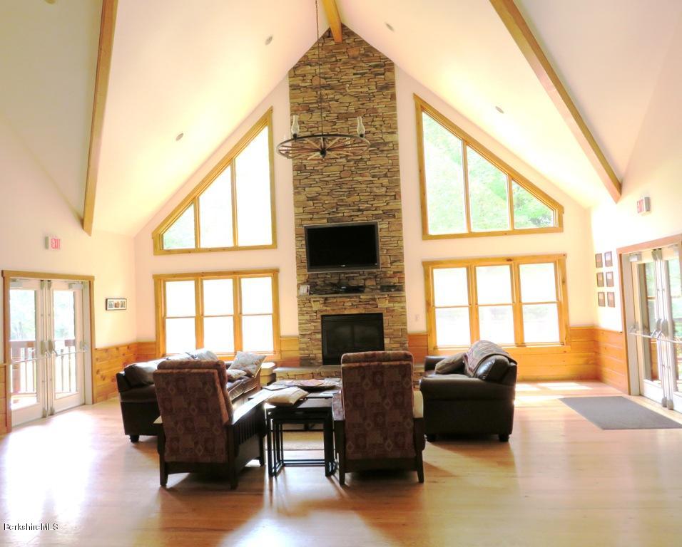 7 Sunset Court Otis, MA 01253 - Photo 12 of 21 a living room with furniture a fireplace and a floor to ceiling window