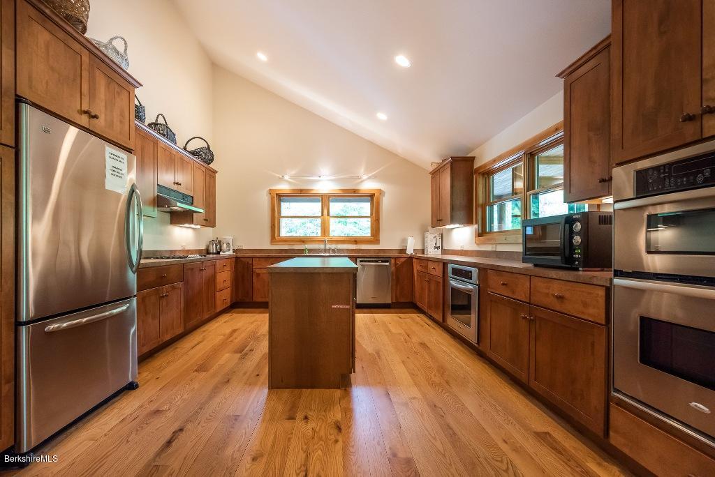 7 Sunset Court Otis, MA 01253 - Photo 14 of 21 a kitchen with stainless steel appliances granite countertop a refrigerator a stove top oven a sink dishwasher and wooden cabinets with wooden floor