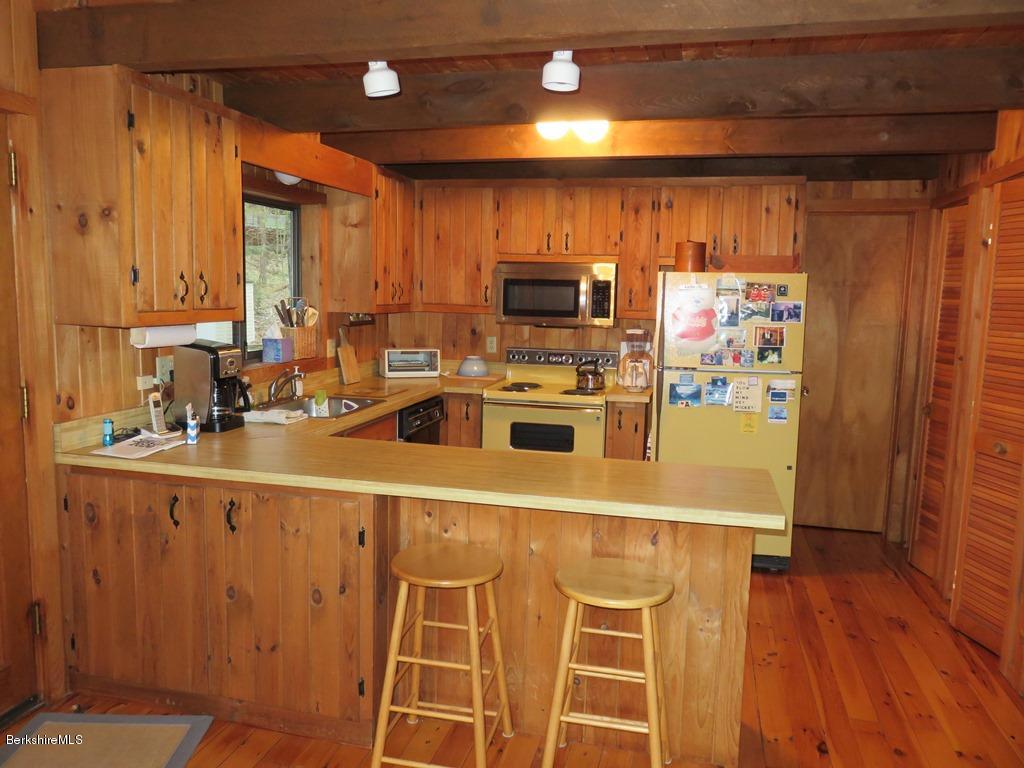 7 Sunset Court Otis, MA 01253 - Photo 4 of 21 a kitchen with stainless steel appliances a microwave a stove and white cabinets