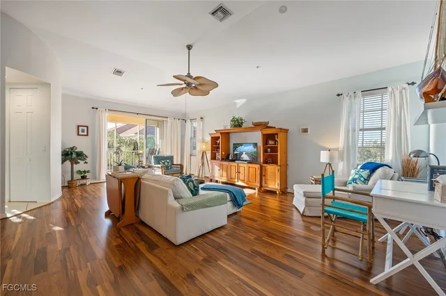 a view of a dining room with furniture a chandelier and wooden floor