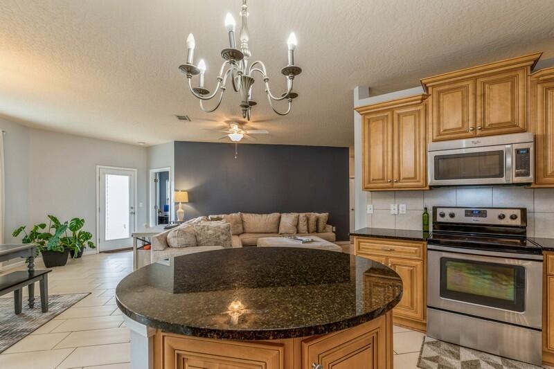 4596 Hermosa Road Crestview, FL 32539 - Photo 11 of 35 a kitchen with stainless steel appliances granite countertop a sink a stove and cabinets