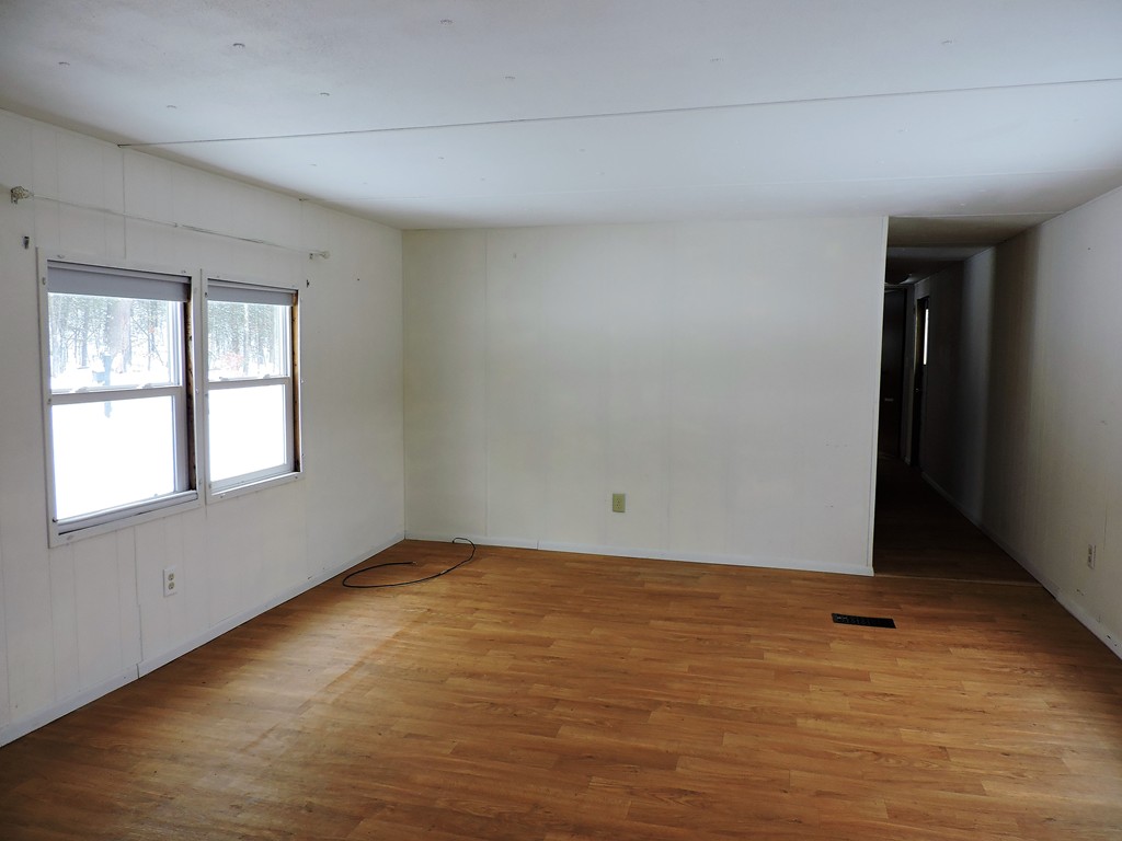 46 Madden Road, Unit 11 West Brookfield, MA 01585 - Photo 3 of 10 a view of an empty room with wooden floor and a window