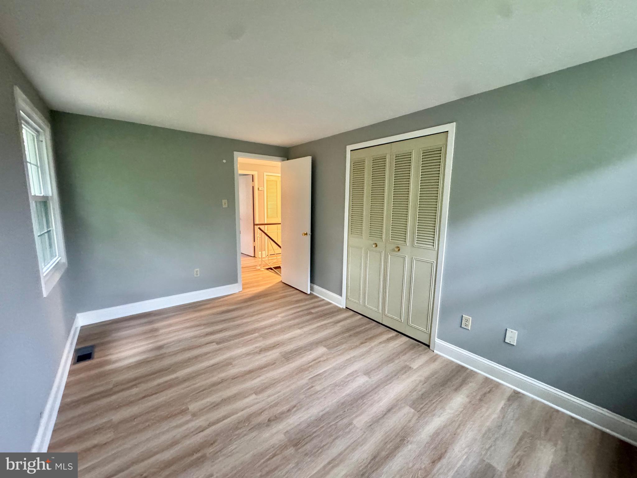 4908 Rocky Spring Lane Bowie, MD 20715 - Photo 26 of 36 an empty room with wooden floor and windows