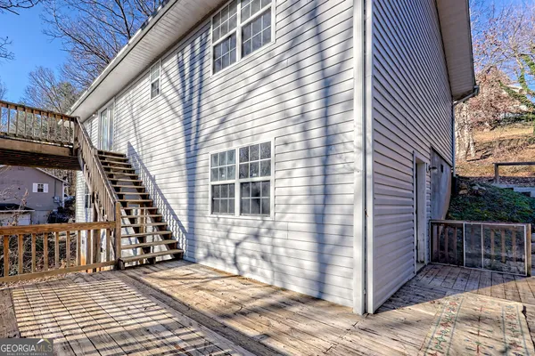 a kitchen with stainless steel appliances kitchen island granite countertop a table chairs in it and wooden floor