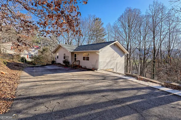 a view of a lush green field with a tree in the background