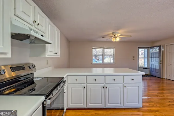 a kitchen with cabinets and wooden floor