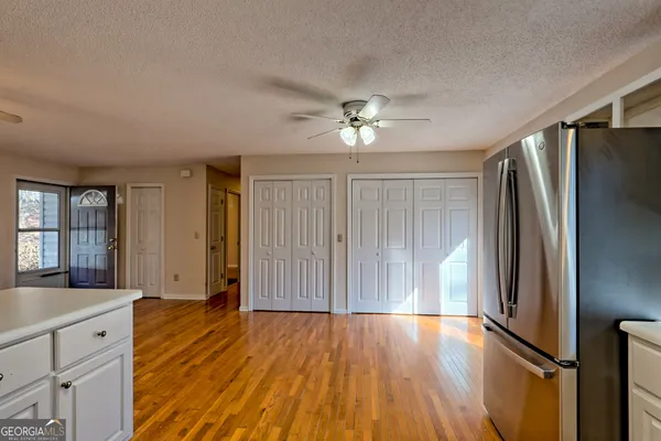 an empty room with wooden floor cabinet and front door