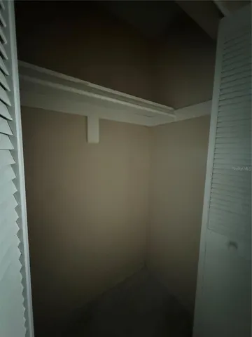 an empty room with large windows and view of balcony