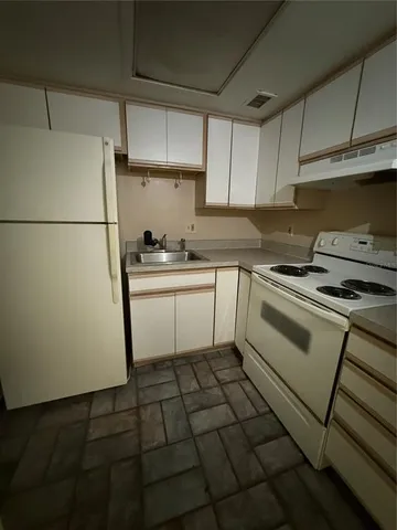 a kitchen with a stove a sink and a refrigerator
