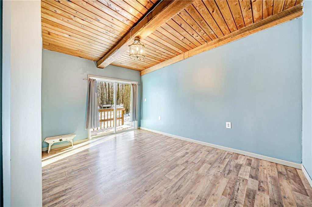 128 Sky Top Road Acme, PA 15610 - Photo 21 of 34 a view of an empty room with wooden floor and a window