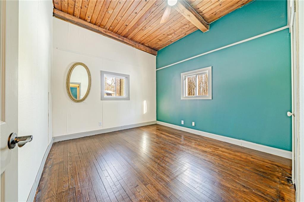 128 Sky Top Road Acme, PA 15610 - Photo 25 of 34 an empty room with wooden floor mirror and windows