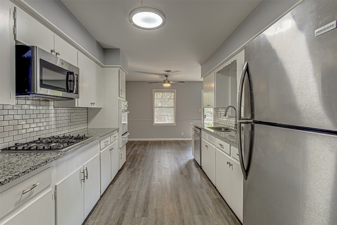 2001 Oakglen Drive Austin, TX 78745 - Photo 11 of 40 a kitchen with stainless steel appliances a refrigerator a stove a sink and white cabinets