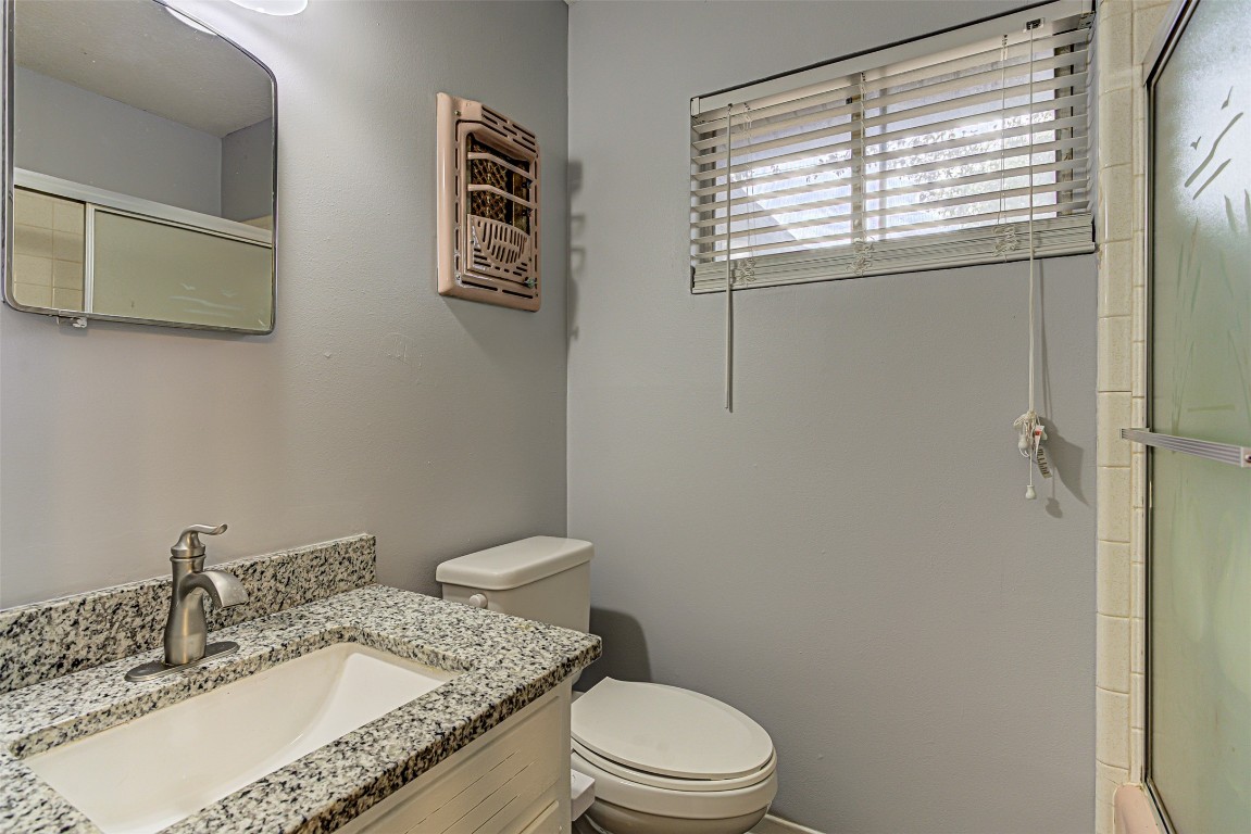 2001 Oakglen Drive Austin, TX 78745 - Photo 30 of 40 a bathroom with a granite countertop sink toilet and mirror