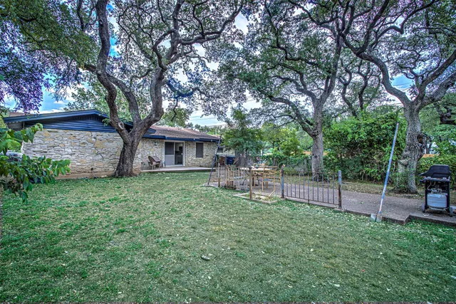 a view of a house with a backyard and a tree