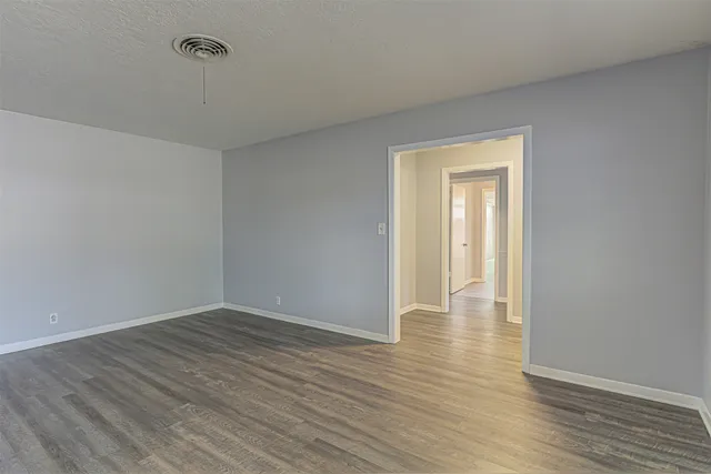 a view of an empty room with wooden floor