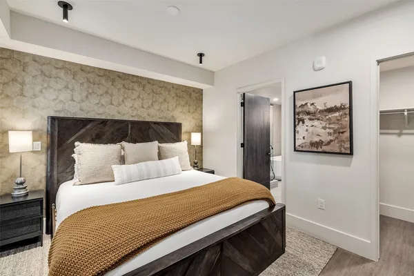 a bedroom with a bed and painting on the wall