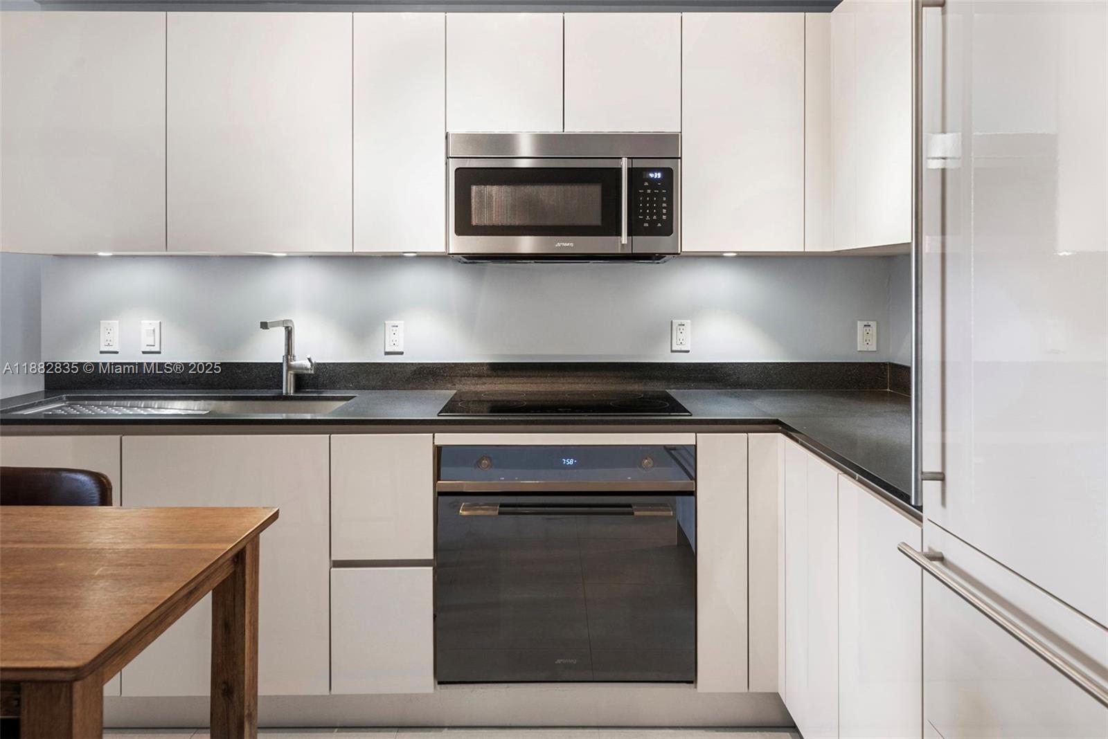 1010 Brickell Avenue, Unit 3610 Miami, FL 33131 - Photo 17 of 37 a kitchen with stainless steel appliances granite countertop a stove microwave and sink