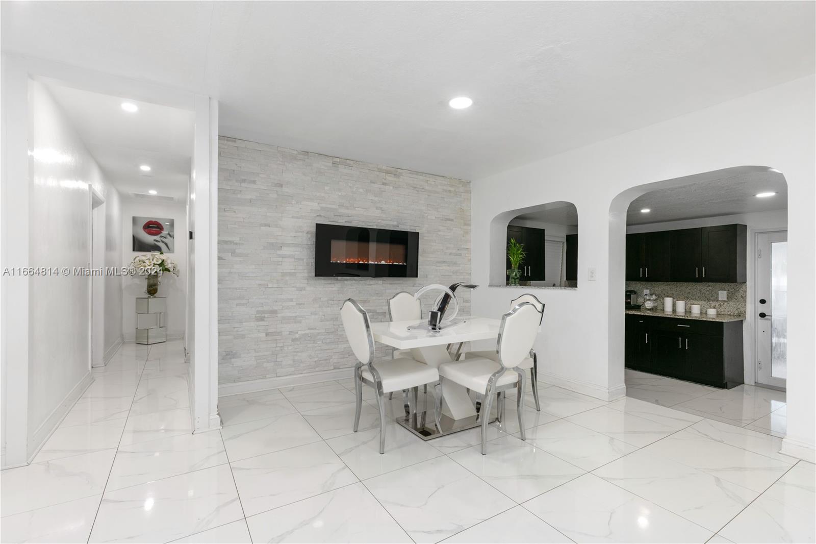750 East 55th Street Hialeah, FL 33013 - Photo 11 of 66 a living room with couches a flat screen tv and kitchen view