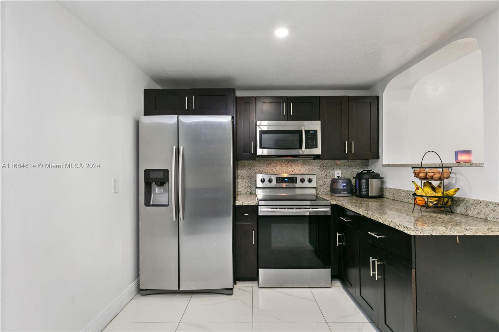 750 East 55th Street Hialeah, FL 33013 - Photo 15 of 66 a kitchen with stainless steel appliances granite countertop a refrigerator a stove top oven a sink and dishwasher