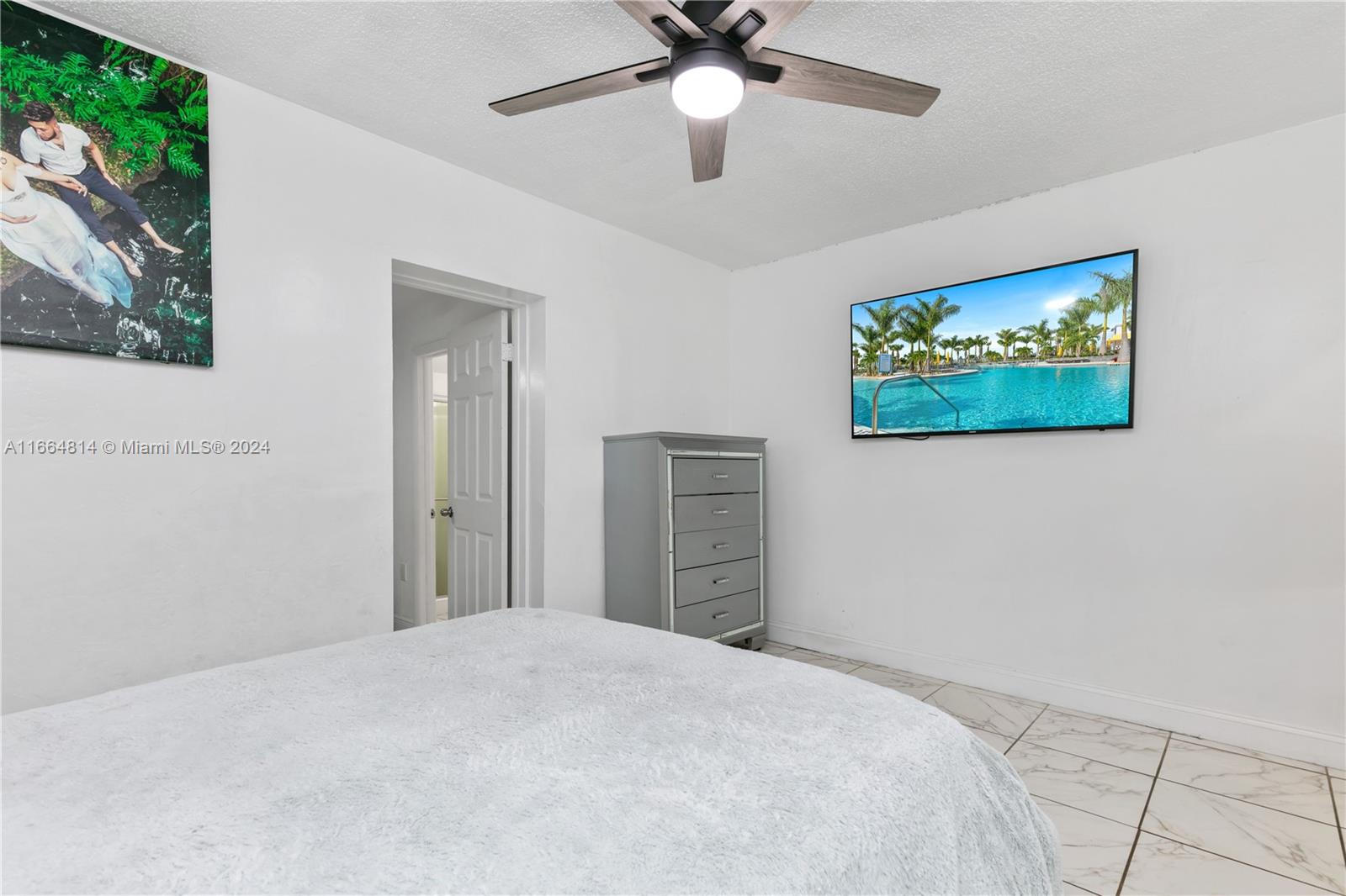 750 East 55th Street Hialeah, FL 33013 - Photo 21 of 66 a bedroom with a bed and a chandelier