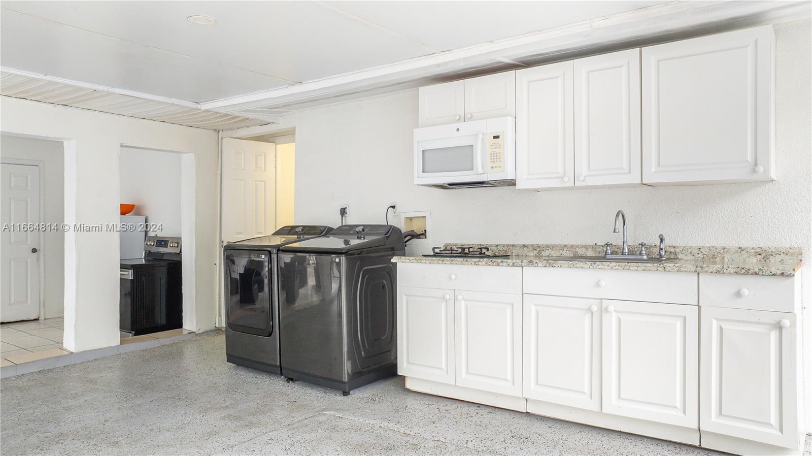 750 East 55th Street Hialeah, FL 33013 - Photo 37 of 66 a kitchen with stainless steel appliances granite countertop a sink and a stove