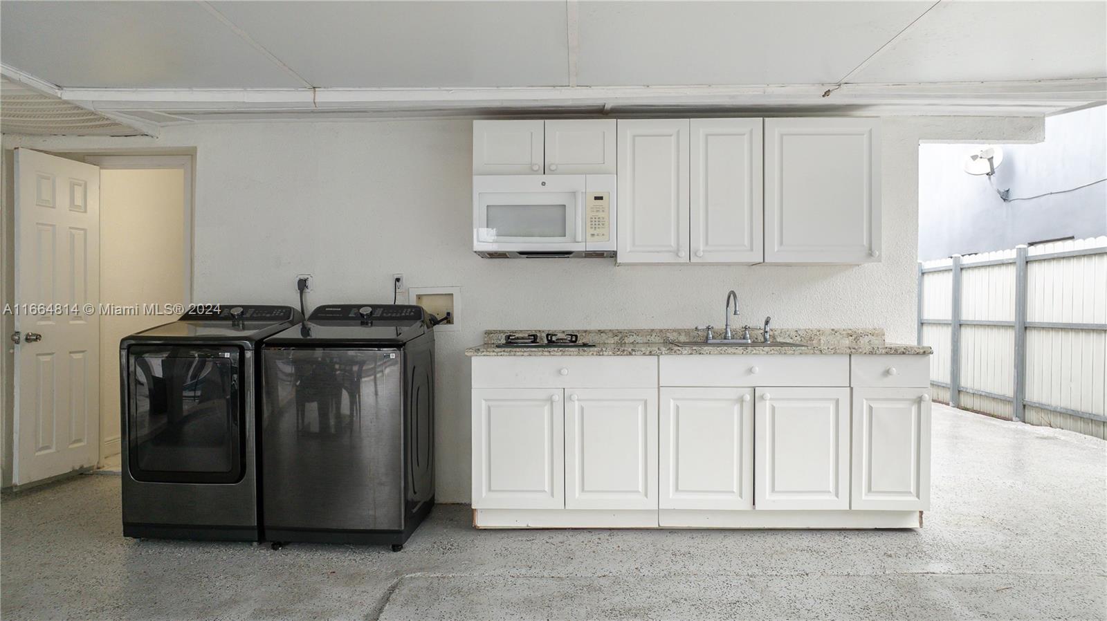 750 East 55th Street Hialeah, FL 33013 - Photo 38 of 66 a kitchen with granite countertop white cabinets and a stove top oven
