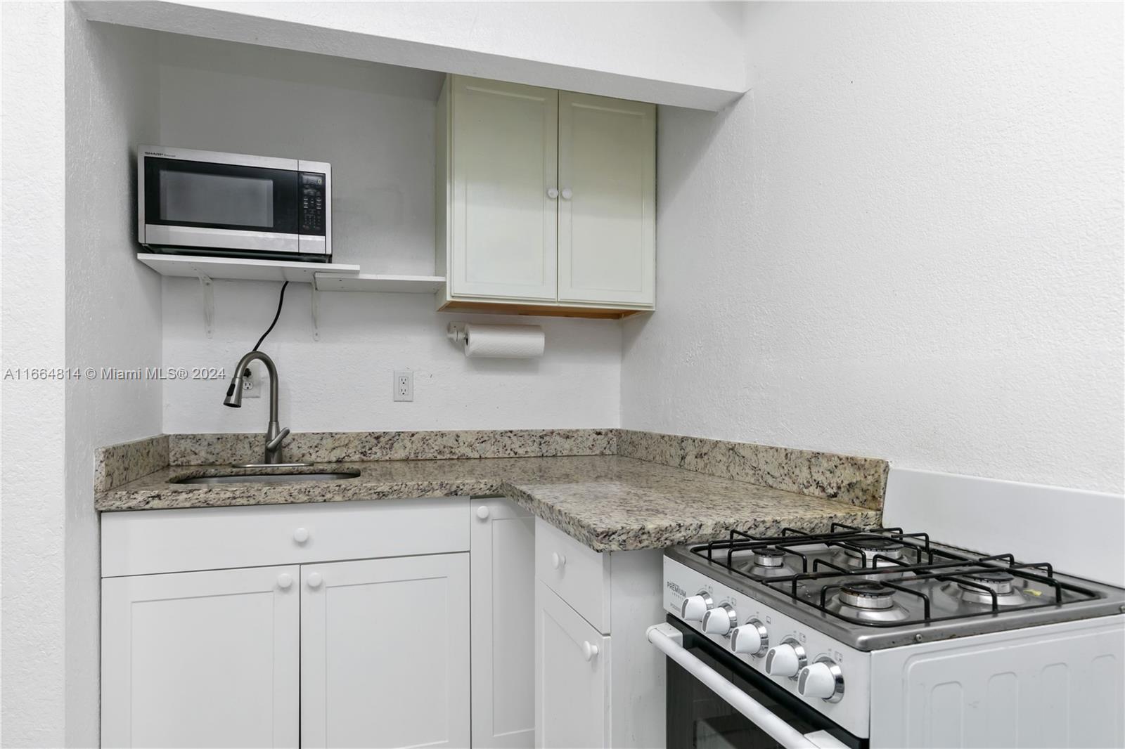 750 East 55th Street Hialeah, FL 33013 - Photo 51 of 66 a kitchen with granite countertop a stove and a sink