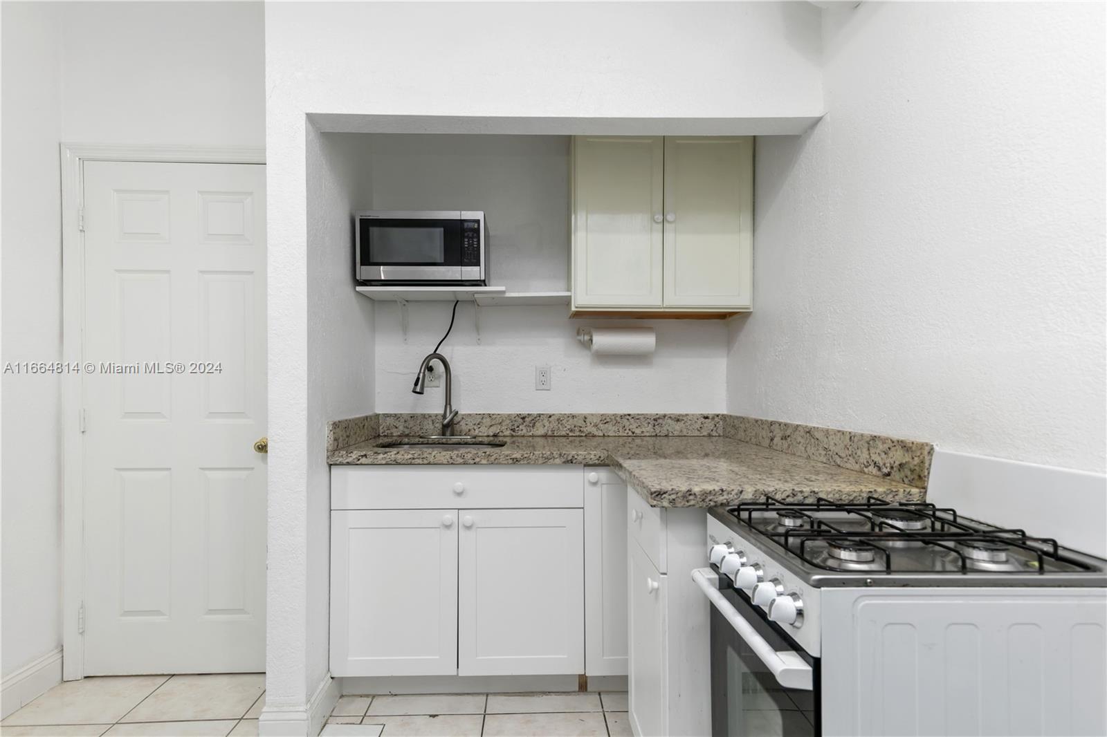 750 East 55th Street Hialeah, FL 33013 - Photo 52 of 66 a kitchen with granite countertop a stove and a sink