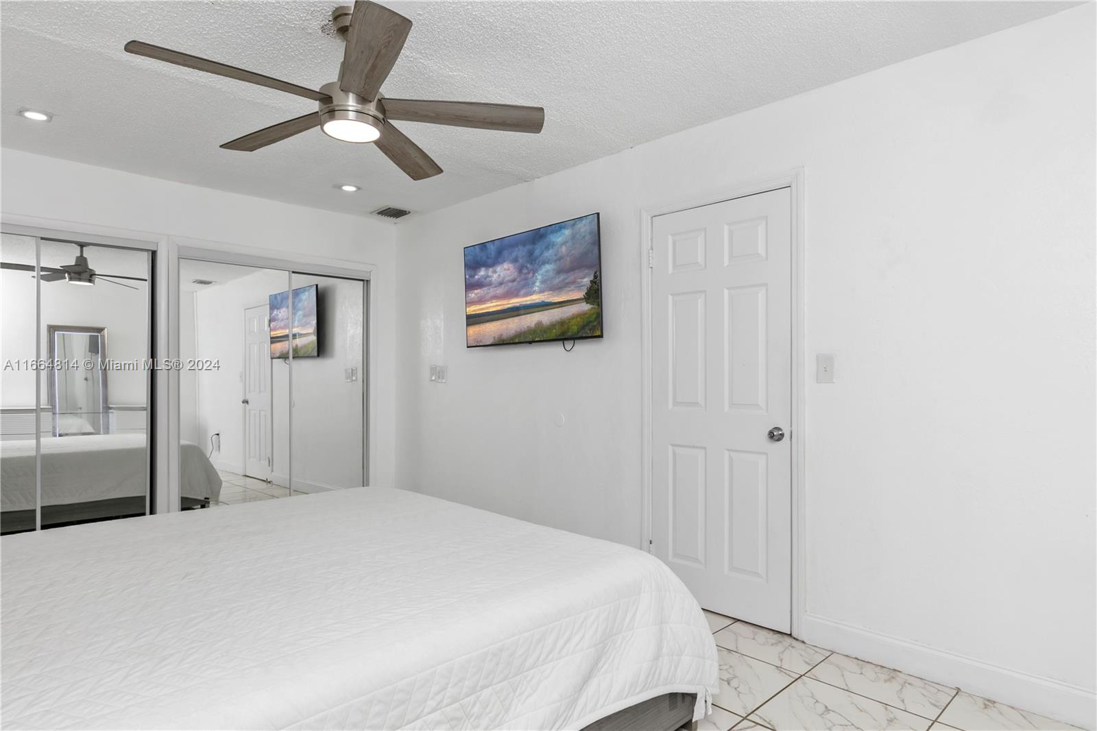 750 East 55th Street Hialeah, FL 33013 - Photo 60 of 66 a bedroom with a large bed and a chandelier