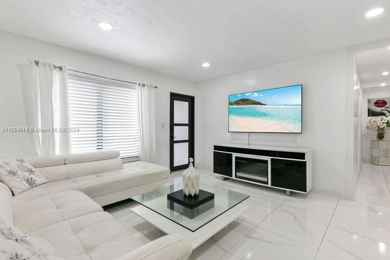 750 East 55th Street Hialeah, FL 33013 - Photo 8 of 66 a living room with furniture a flat screen tv and a fireplace