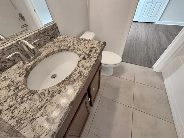 a bathroom with a granite countertop sink and a mirror