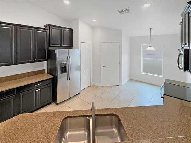 a kitchen with stainless steel appliances granite countertop a sink refrigerator and microwave