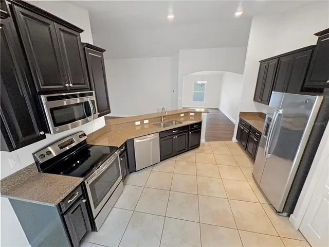 a kitchen with sink refrigerator and stove