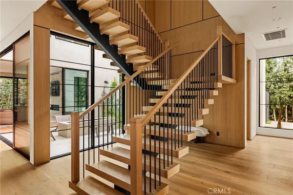 a view of staircase with lots of frames on wall and a window