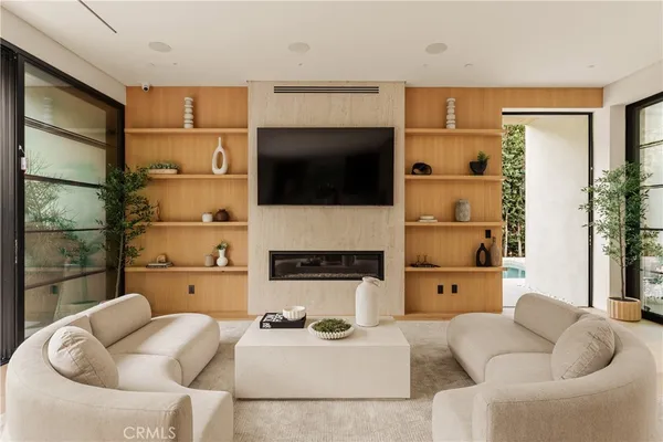 a living room with furniture a flat screen tv and a floor to ceiling window